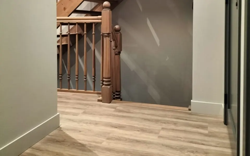 Hoge witte plinten in een royaal afgewerkte hal bij een houten trap