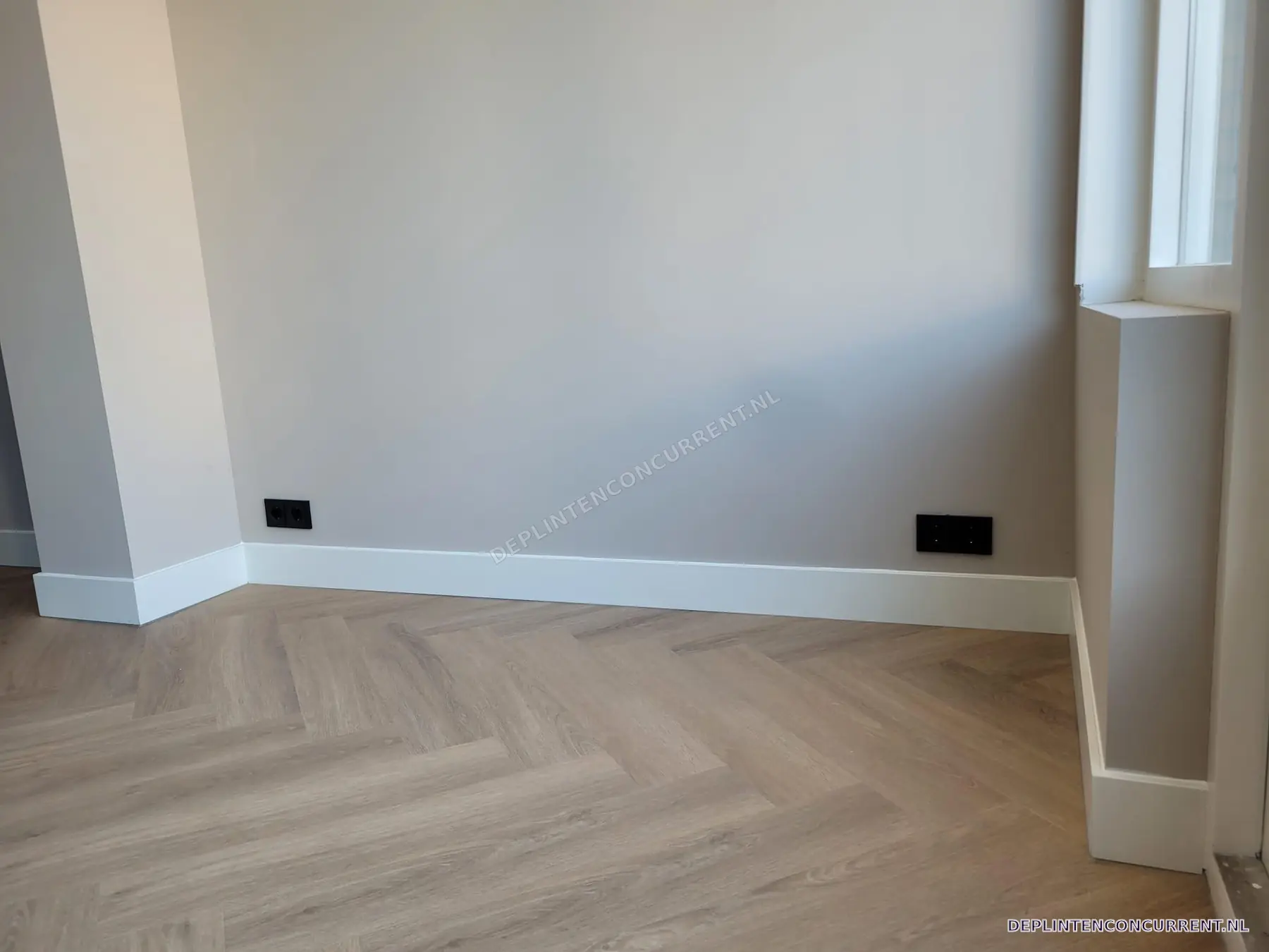 Hoge witte plinten langs een visgraatvloer