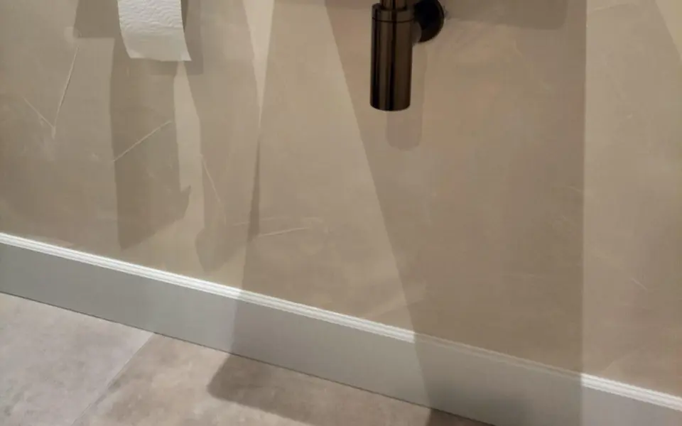 Geprofileerde plint in een warm afgewerkte toiletruimte