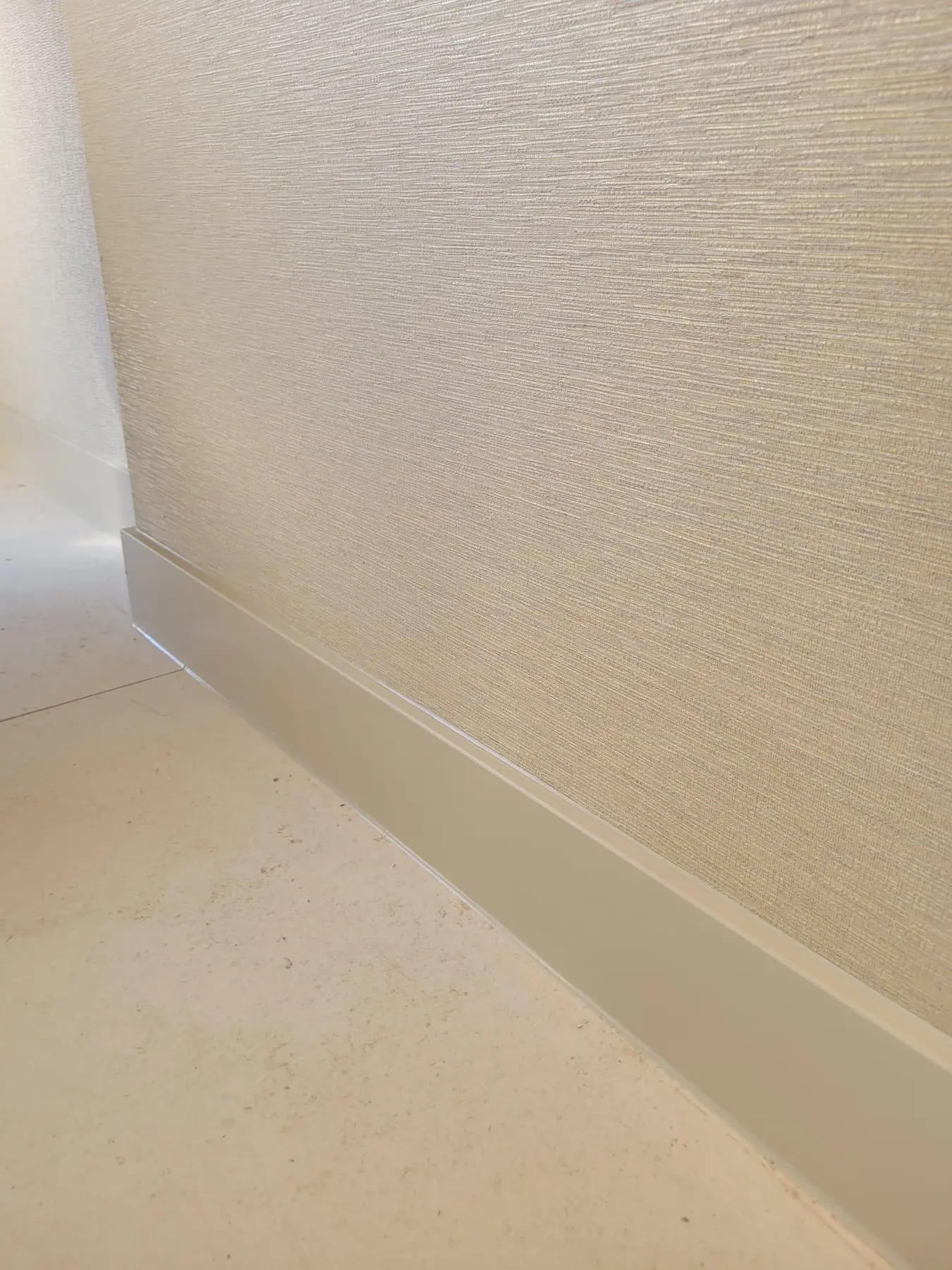 Detail van een beige sfeerplint bij een wand met structuur